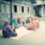 Women gather in the courtyard near their homes to discuss nutrition with project staff.