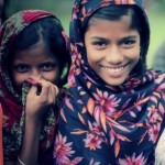 Two young girls enjoy playing with other children after school.