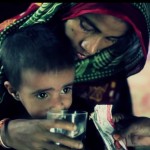 A mother feeds her child "plumpy nut" to battle malnutrition.