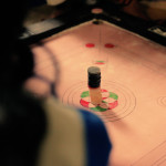 Youth gather together to play their favorite local game, carrom board.