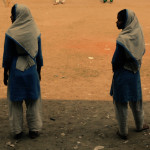 Adolescent girls play soccer on their breaks during school.